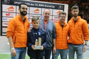 Tom Bischof wurde 2019 als bester Spieler des BWK-Arena-Cups ausgezeichnet. Er erhielt den Pokal, den er immer noch in seinem alten Kinderzimmer bei seinen Eltern stehen hat, von den Turnierorganisatoren Dario Caeiro (links), Jens Betsch (Zweiter von rechts) und Florian Bader (rechts) sowie von Namenssponsor Hartmut Layer. © Joachim Mayershofer​