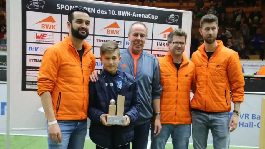 Tom Bischof wurde 2019 als bester Spieler des BWK-Arena-Cups ausgezeichnet. Er erhielt den Pokal, den er immer noch in seinem alten Kinderzimmer bei seinen Eltern stehen hat, von den Turnierorganisatoren Dario Caeiro (links), Jens Betsch (Zweiter von rechts) und Florian Bader (rechts) sowie von Namenssponsor Hartmut Layer. © Joachim Mayershofer​